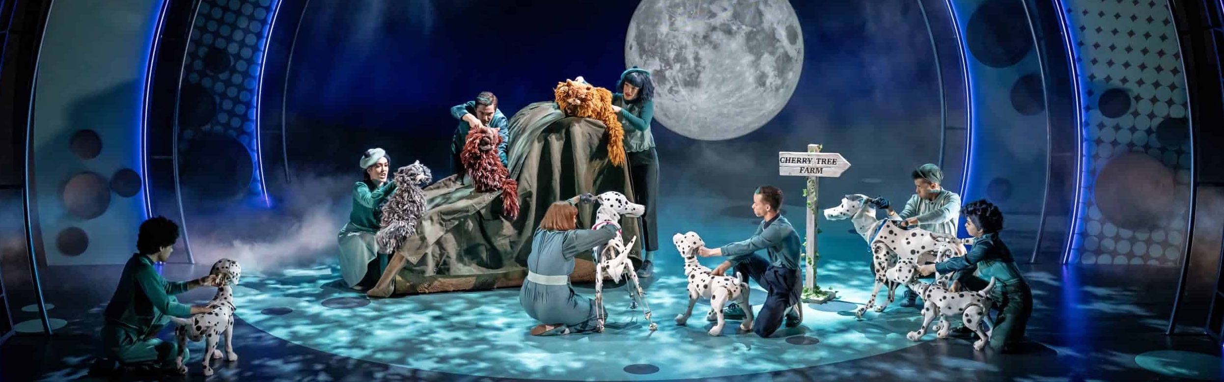 Puppets onstage in 101 Dalmatians, a family of Dalmatians and 3 cats